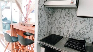 Una cucina compatta con piano cottura integrato, un piccolo frigorifero e un'area pranzo con sedie.