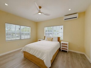 Ein Schlafzimmer mit Bett, Nachttisch und Deckenventilator.