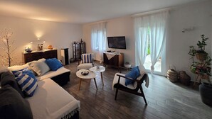 A living room with a sofa, armchair, coffee table, TV, and a cabinet. - Mediterranean oasis of peace- 100 m from the sea, private garden ful fenced yard (Banjole)