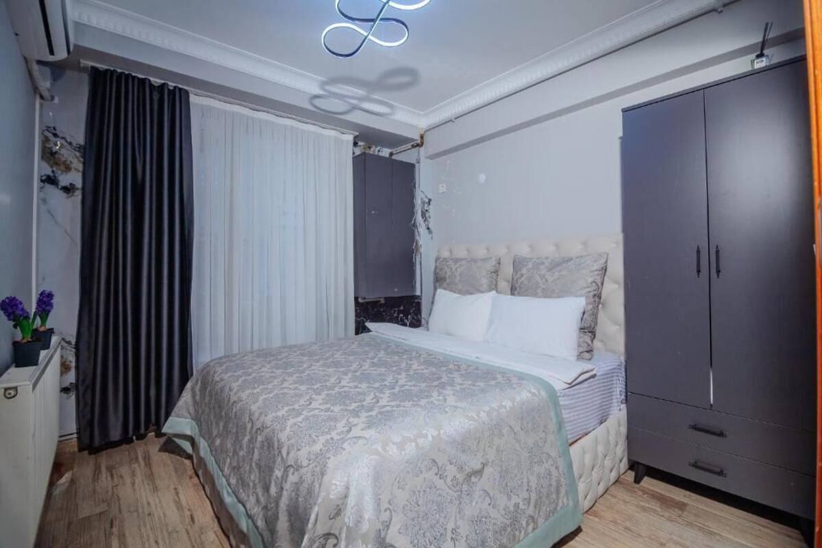 Ein Schlafzimmer mit Bett, Kleiderschrank und einer Deckenleuchte.