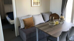 Ein gemütlicher Wohnraum mit Sofa, Esstisch und einer kleinen Küchenzeile.