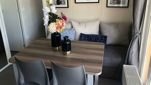 Ein Essbereich mit einem Holztisch, zwei schwarzen Vasen mit Goldakzenten und einer Blumenkomposition.