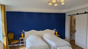 A bedroom with two single beds, a chair, a lamp, and a wardrobe. - Flexible & comfy guest room with mountain view (Montaillou)