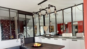 Una cocina moderna con una isla central, electrodomésticos de acero inoxidable y un amplio ventanal.