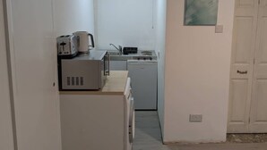 Eine kleine Küche mit Toaster, Wasserkocher, Spüle und einem kleinen Herd.