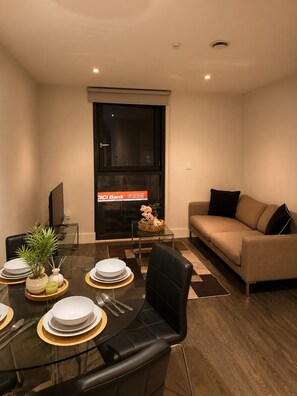 A modern living room with a dining area, a sofa, and a television. - Central Manchester Retreat | AO Arena & NQ (Manchester)