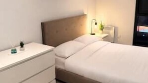 Une chambre à coucher avec un lit, une table de chevet et une commode.