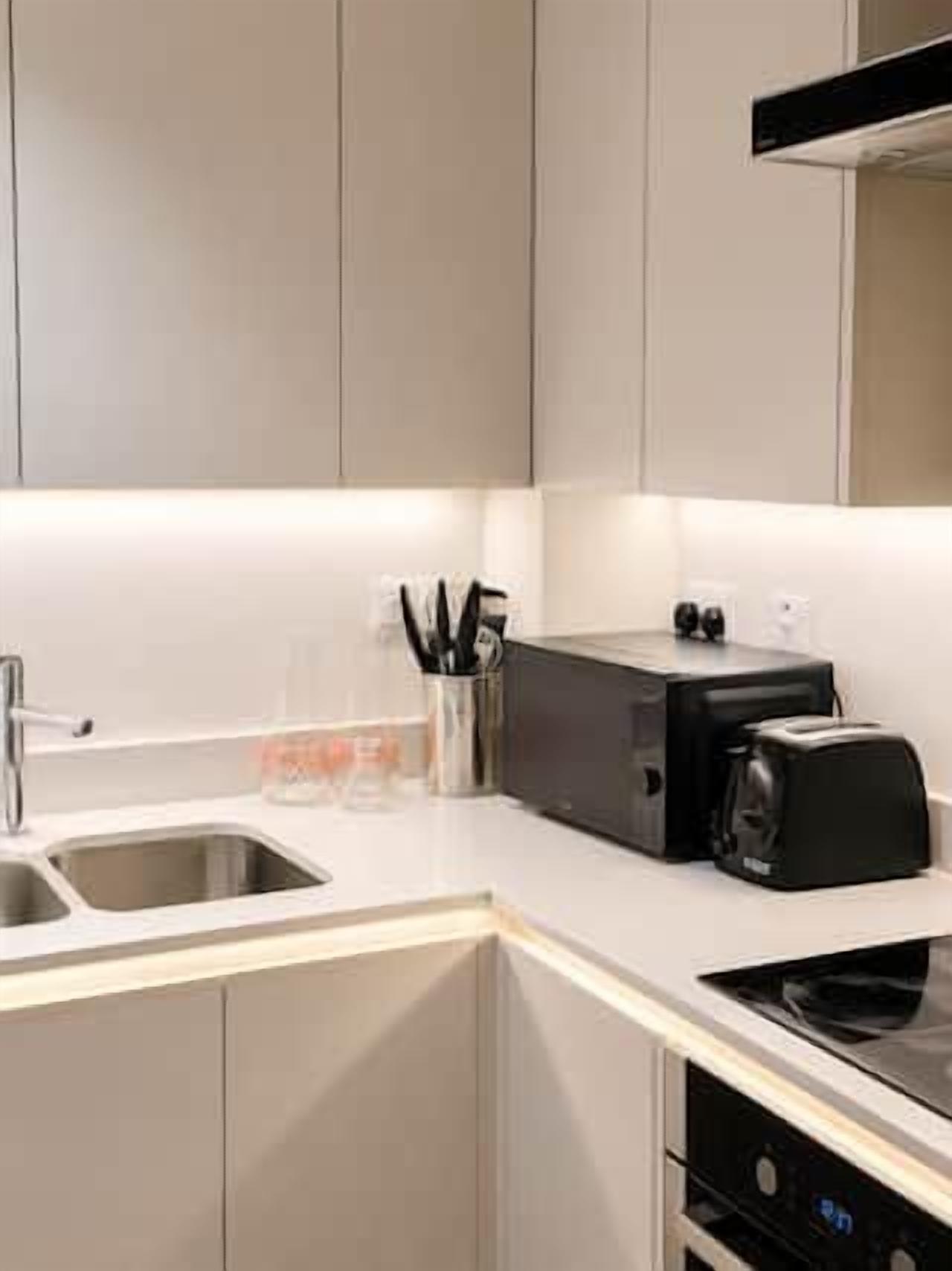 A modern kitchen with a built-in dishwasher, a toaster, and a sink.