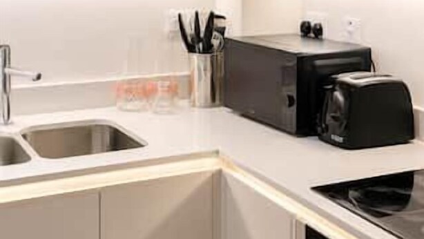 Une cuisine moderne équipée d’un lave-vaisselle encastré, d’un grille-pain et d’un évier.