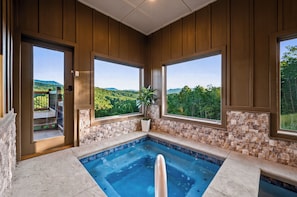 A spa area with a hot tub, large windows, and a view of the outdoors. - Indoor Pool | Golf Sim | Pickleball | Sleeps 20 (Sevierville)