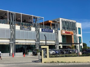 Ein modernes Gebäude mit einem Restaurant namens 'Taizhou DAO Restaurant' und 'Mezza Luna Mediterranean Fusion' im Erdgeschoss.