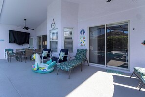 A covered patio with outdoor furniture, a ceiling fan, and a glass door leading to an outdoor area. - Pelicans Landing - Three Bedroom House, Sleeps 6 (Davenport)