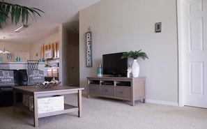 A living room with a television, a coffee table, and a bookshelf. - Sunset Ridge Villa - Five Bedroom House, Sleeps 10 (Davenport)