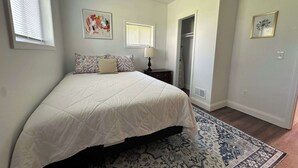 A bedroom with a bed, a ceiling fan, a window, a door, and a rug. - Beautiful 2 Bedroom Apartment - Easy City Access (Pittsburgh)