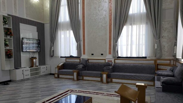 A spacious living room with a large flat-screen TV, two sofas, a coffee table, and a TV stand with a clock. - OROMIA LUXURY VILLA
Excellent 5-bedrooms in pleasant Shashemene for your stay (Shashemene)