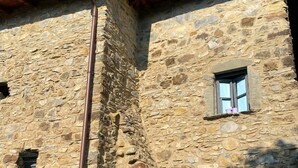 Ein Steinhaus mit einem Fenster und einem kleinen Balkon.