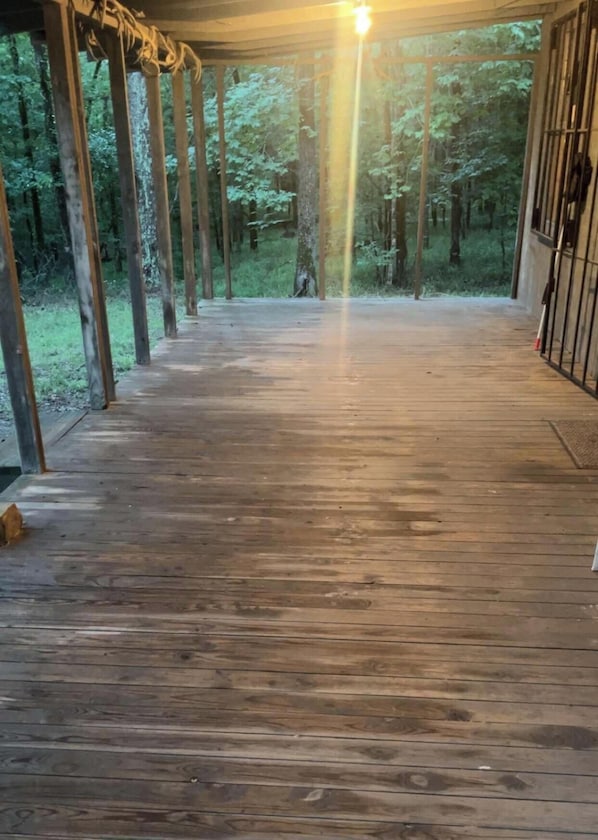 Eine Holzdielen-Terrasse mit Blick auf einen Wald.