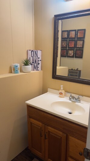 Ein Badezimmer mit Waschbecken, Spiegel und einem Schild mit der Aufschrift 'ON TIME'.