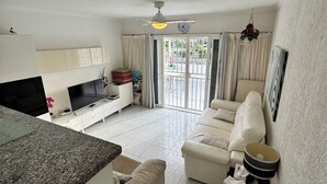 A modern living room with a sofa, TV, and a dining area with a table and chairs. - Relaxation, comfort, and unforgettable views (Costa Adeje)