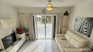 A living room with a TV, sofa, and a painting. - Relaxation, comfort, and unforgettable views (Costa Adeje)