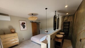 Une salle de bain moderne avec une baignoire sur pieds, un meuble-lavabo avec un vasque, un grand miroir et un luminaire au plafond.