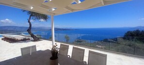 Ein Balkon mit freiem Blick auf das Meer und die Berge.