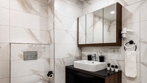 Ein modernes Badezimmer mit Toilette, Waschbecken und einem Spiegel darüber.