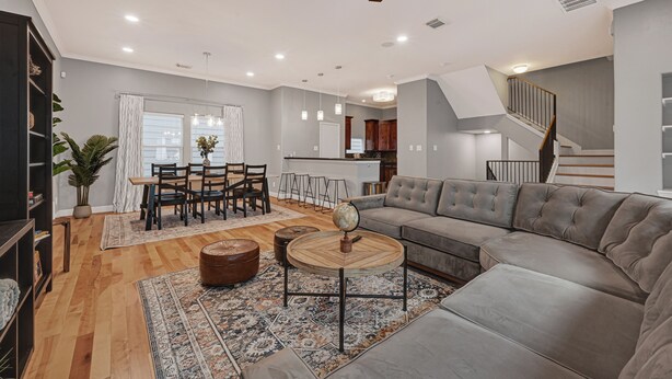 A modern living room with a sofa, coffee table, and dining area. - Modern EaDo Home - Walk to Convention Center, Stadiums & Downtown (Houston)