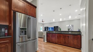 A modern kitchen with stainless steel appliances, wooden cabinets, and a tiled backsplash. - Modern EaDo Home - Walk to Convention Center, Stadiums & Downtown (Houston)