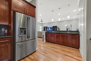 A modern kitchen with stainless steel appliances, wooden cabinets, and a tiled backsplash. - Modern EaDo Home - Walk to Convention Center, Stadiums & Downtown (Houston)