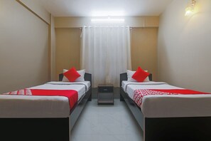 A twin room with two beds, a nightstand, and a curtain.