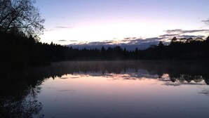 A calm lake at dusk with a forested shoreline. - Vacation apartment Gute Zeit Hahnenklee (Goslar)