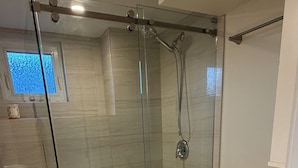 Ein Badezimmer mit Duschkabine, Toilette und Waschbecken.
