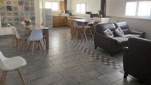 A spacious living area with a dining table, chairs, a sofa, and a kitchen in the background. - Country house (Malataverne)