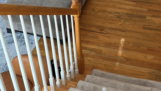 A staircase with a wooden handrail leading to a grey sofa with a yellow pillow. - Spacious 3BR Downtown Atlanta Home w/ Parking Minutes to Mercedes-Benz Stadium (Atlanta)