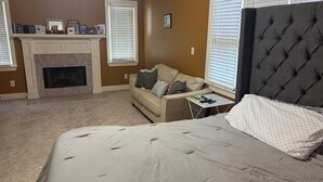A bedroom with a bed, a sofa, a fireplace, and a window with blinds. - Spacious 3BR Downtown Atlanta Home w/ Parking Minutes to Mercedes-Benz Stadium (Atlanta)