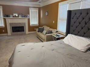 A bedroom with a bed, a sofa, a fireplace, and a window with blinds. - Spacious 3BR Atlanta Home  3 Parking Spaces  Minutes to Mercedes-Benz Stadium (Atlanta)
