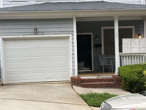 A residential house with a garage, a porch with a chair, and a small garden. - Spacious 3BR Downtown Atlanta Home w/ Parking Minutes to Mercedes-Benz Stadium (Atlanta)