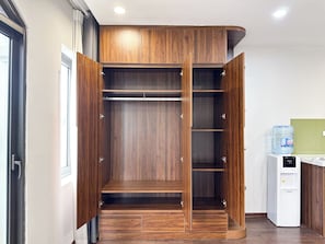 Un vestidor amplio con varias estanterías y cajones, un dispensador de agua y una ventana.