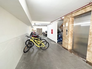 A clean, modern hallway with a bike rack, an elevator, and a water dispenser. - Hannari Cozy Serviced Apartment (Hanoi)