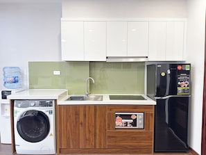 Cocina compacta con lavadora, refrigerador, pileta y placares.