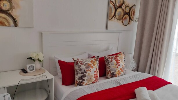 Ein Hotelzimmer mit Bett, Schreibtisch, Stuhl und einem Bild an der Wand.