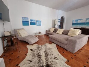 A living room with a sofa, a coffee table, a rug, and wall art. - Family Villa Mareluna in Lido Marini with a private pool, located near the Ionian Sea (Lido Marini/Com. Salve)