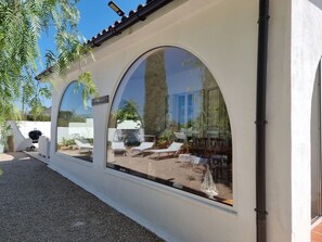 A building with large arched windows, a gravel path, and outdoor seating. - Family Villa Mareluna in Lido Marini with a private pool, located near the Ionian Sea (Lido Marini/Com. Salve)