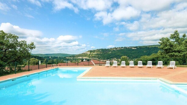 A swimming pool with lounge chairs, surrounded by greenery and hills. - Lovely Duplex With Scenic Terrace (Carayac)