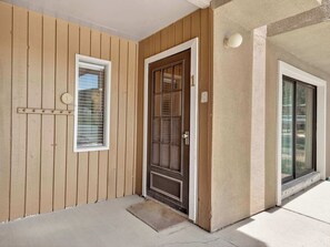 A wooden exterior wall with a door, a window, and a light fixture. - Brian Head Village M1 (Brian Head)