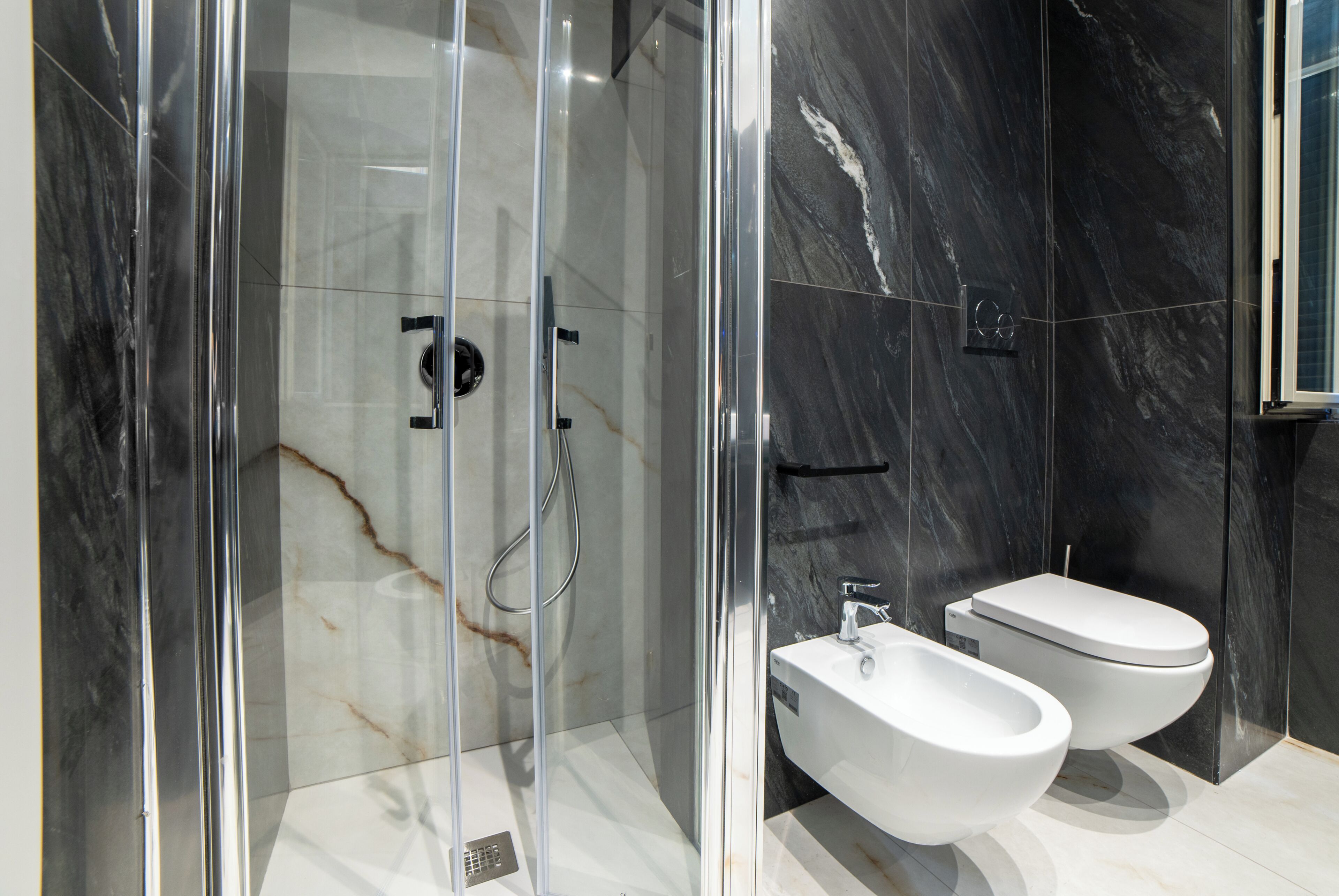 Une salle de bain moderne avec une douche à parois de verre, un lavabo blanc et des toilettes.