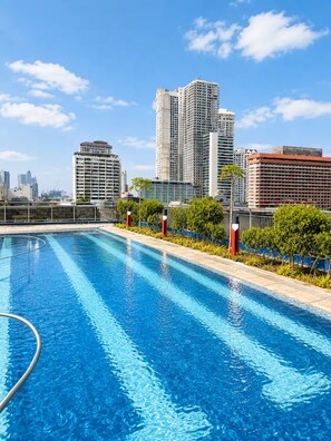 Ein Schwimmbecken mit Stadtansicht im Hintergrund.