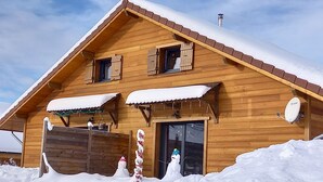 Eine Holzhütte mit geneigtem Dach, Schornstein und Satellitenschüssel.
