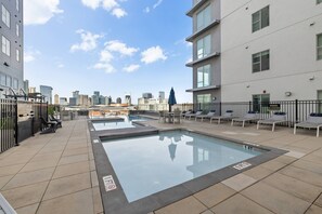 A rooftop pool area with lounge chairs and a view of the city skyline. - Bach HQ | Walk to Broadway | Arcade + Pool (Nashville)